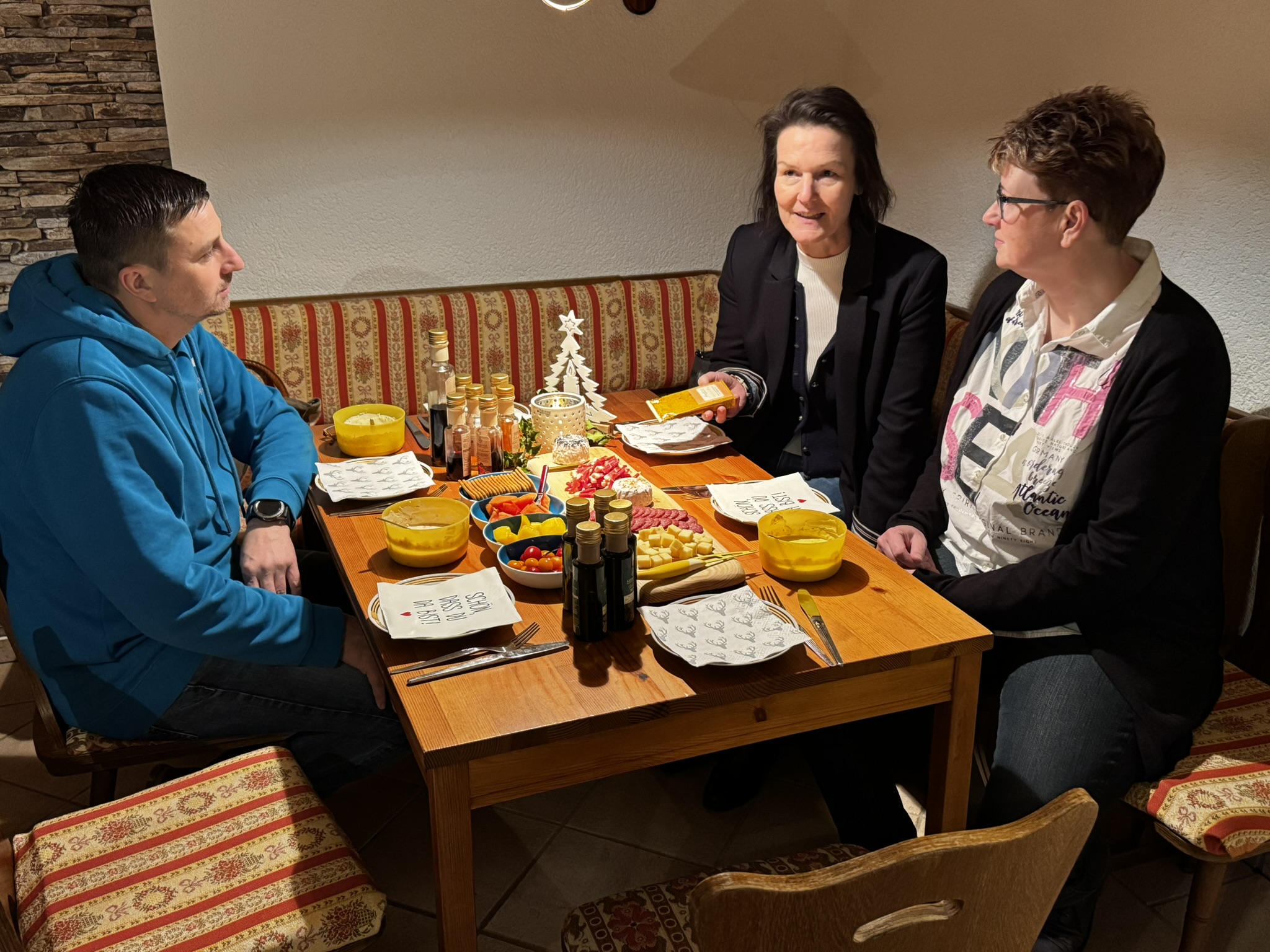 Zu Tisch, bitte: Nico Hannes (l.) und Ehefrau Astrid (r.) luden Landrätin Peggy Greiser zur Verkostung der in Viernau vertriebenen Produkte ein.